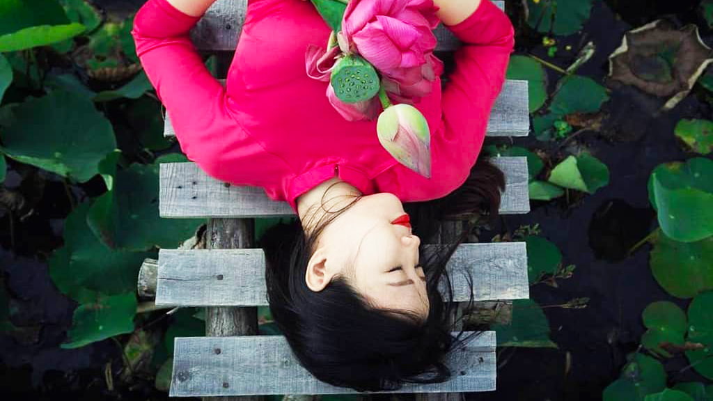 Người con gái Việt Nam đẹp trong tà áo dài với hoa sen